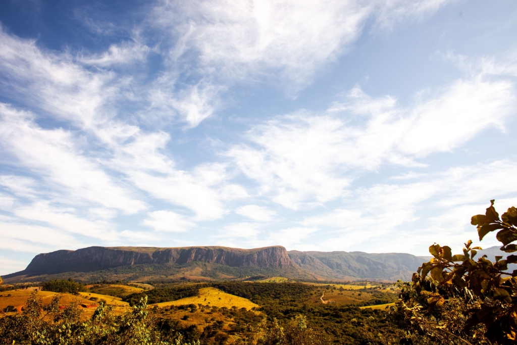 view of a mountain range with a clear blue sky and scattered clouds